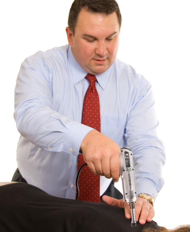 A man wearing a blue shirt receives chiropractic care.