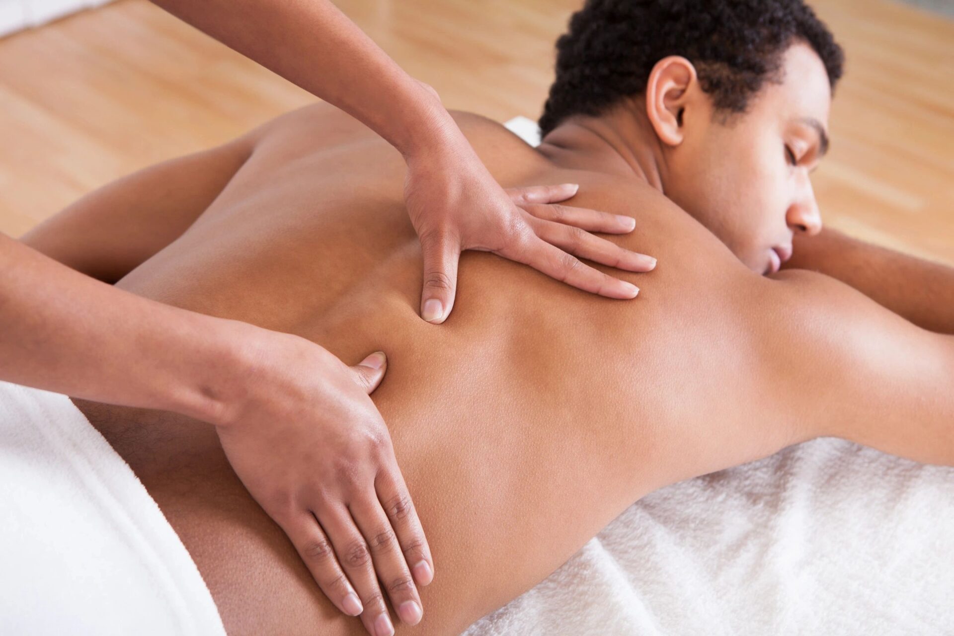 A man getting a back massage at a spa.