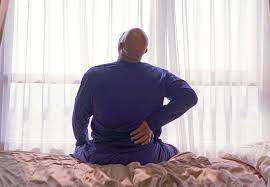 A Bald Man Having Severe Back Pain